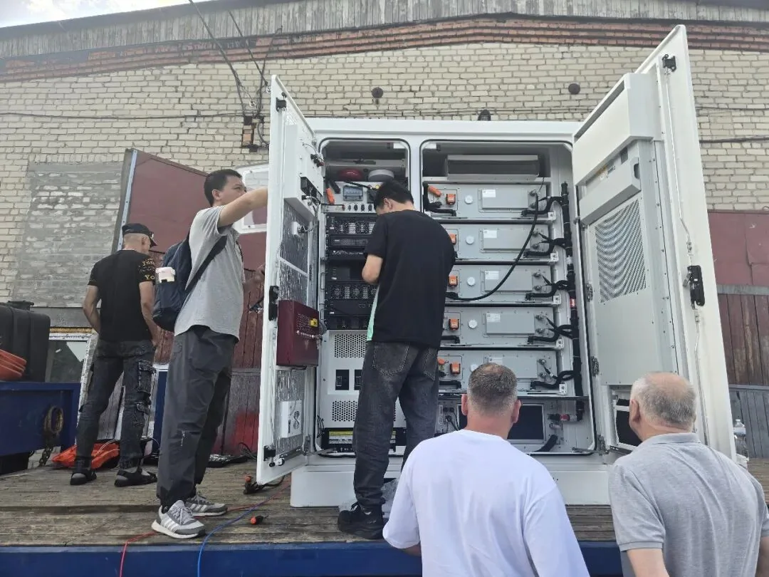 Technical team inspecting integrated equipment inside an enclosure